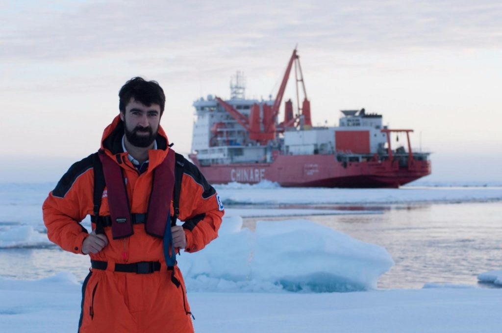 Andrew standing on ice in front of research ship