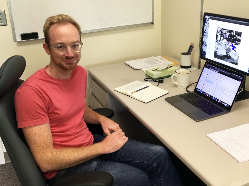 Brian posing with his computer in Wallace Hall