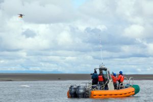 Researcher in raft flying a drone