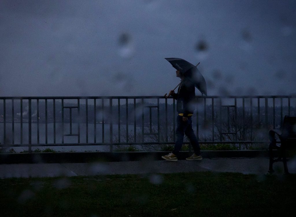 person walking in the rain on a dark day in Seattle