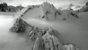 Fog settles under a snow covered ridge line
