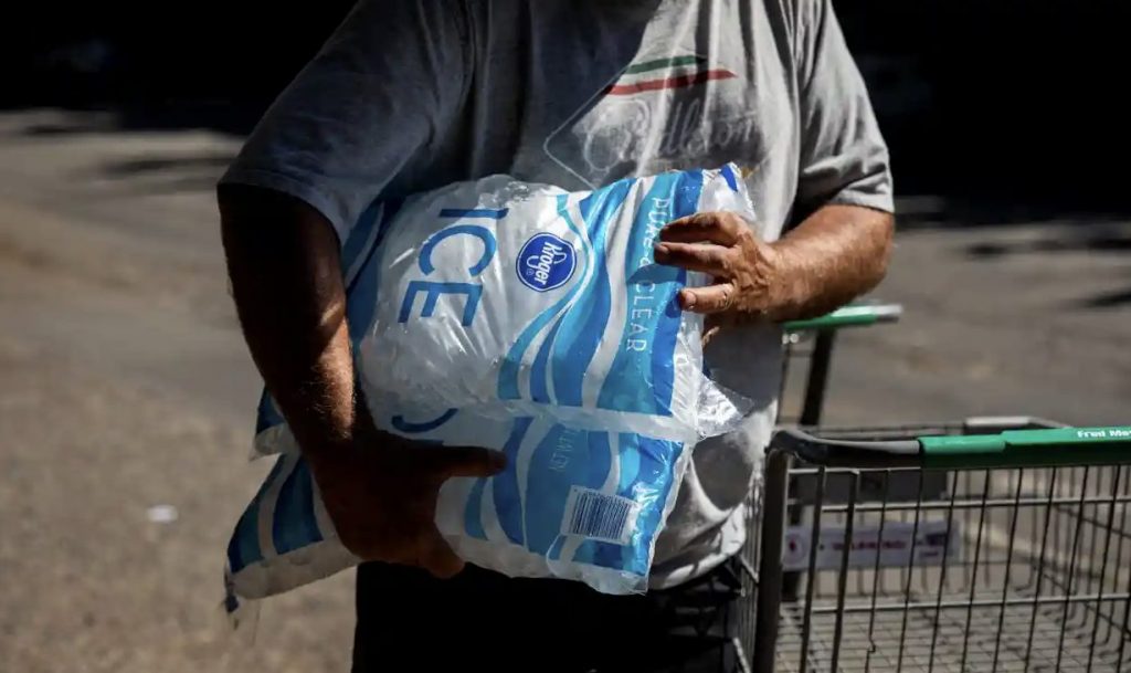 Man with two bags of ice under his right arm