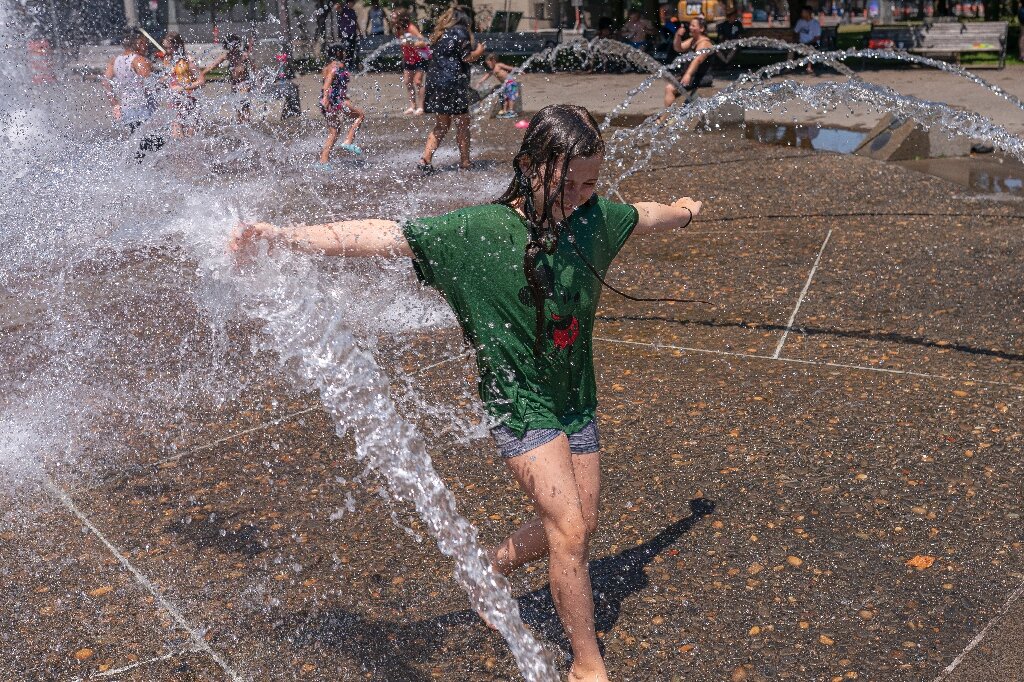 Girl playing in fountain on a very hot day