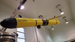 A seaglider hanging from wire inside a building.