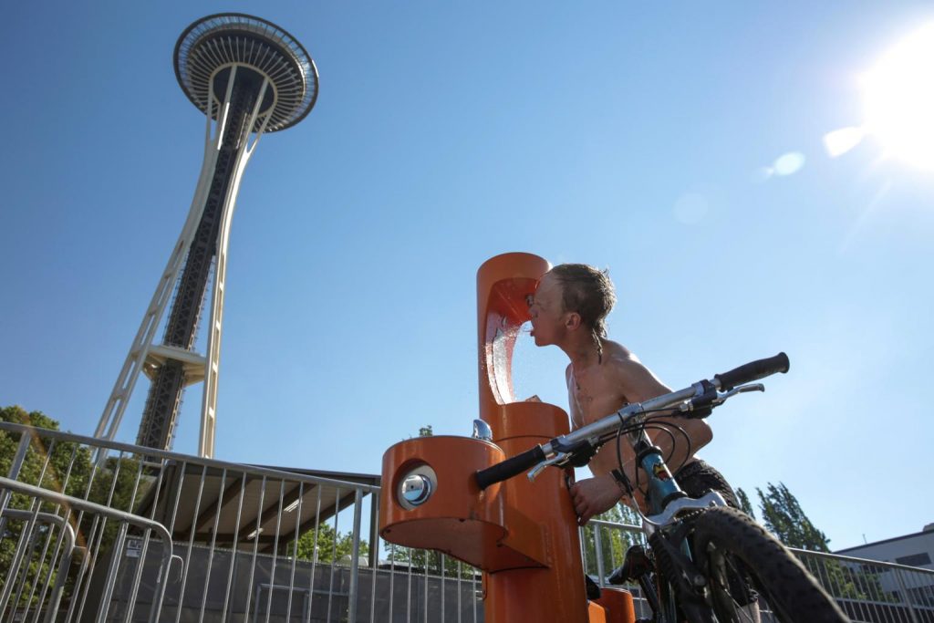 kid drinking from fountain under space needle