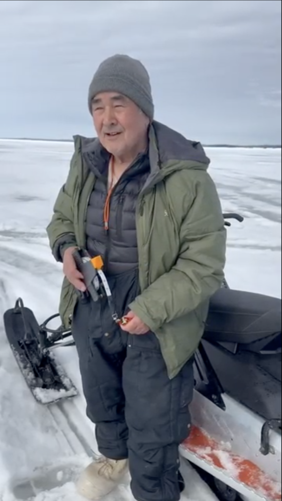 Bobby Schaeffer standing next to a snow mobile.