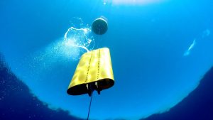 A wirewalker as seen from underwater. It looks like a yellow box on a metal wire.