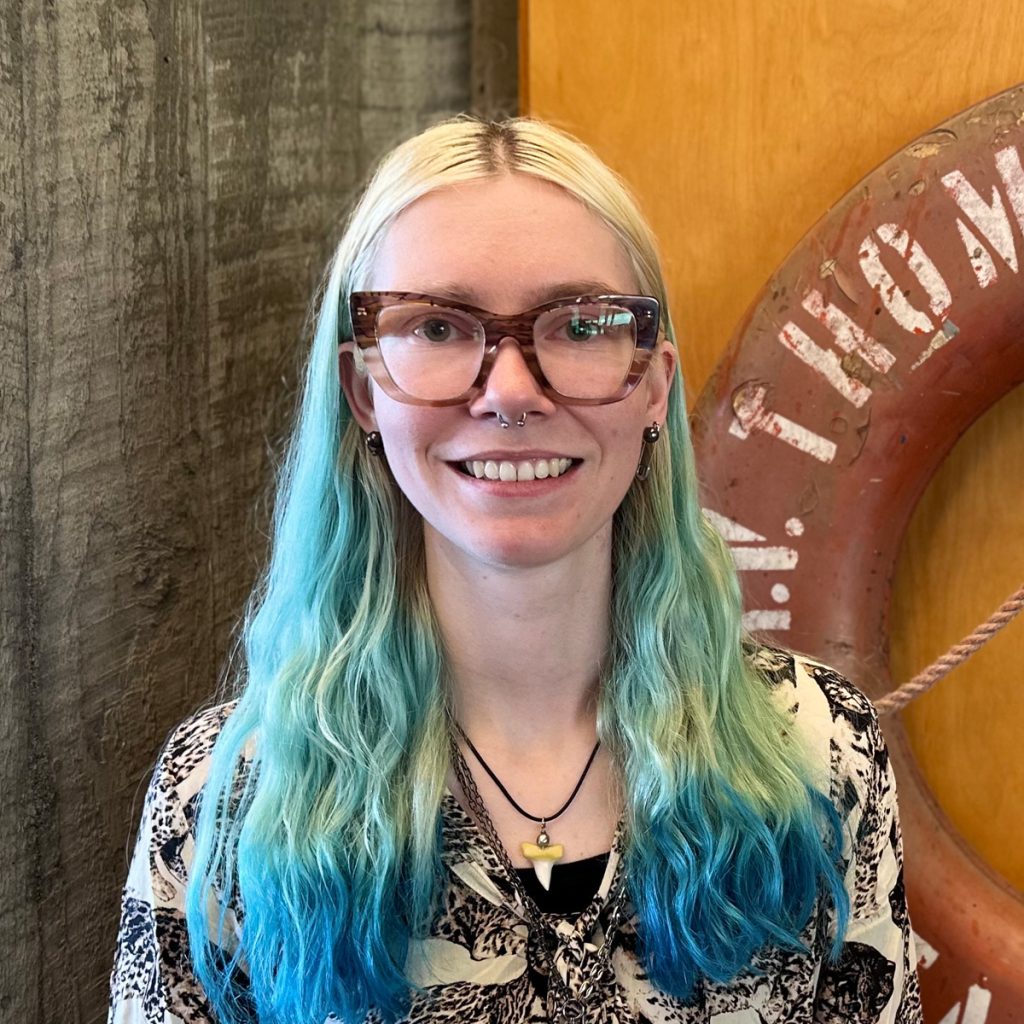 Headshot of Jordan Winter, with a ship's life saver behind her.