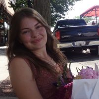 Headshot of Lauren Frake, holding flowers.